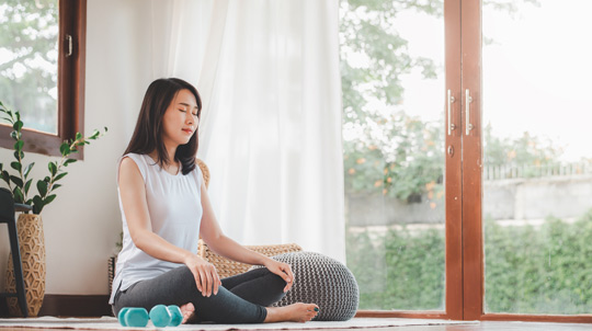 Woman breathing fresh indoor air during her yoga stretch